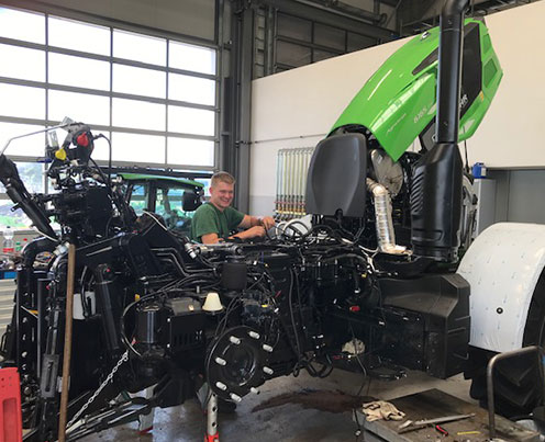 service reparatur und wartung mann repariert traktor in werkstatt