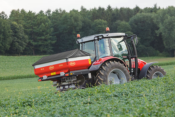 duengerstreuer vicon an traktor fahren auf grünem feld